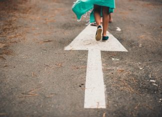 person walking on arrow street sign