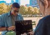 man and woman sitting while using MacBook Pro