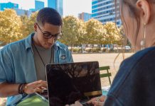 man and woman sitting while using MacBook Pro
